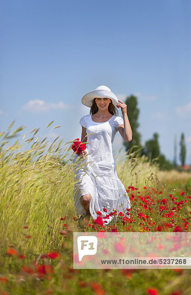 Frau geht im Blumenfeld spazieren