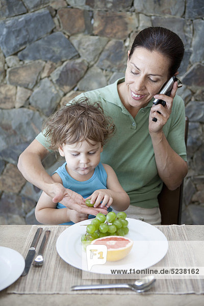 Woman eating breakfast with son