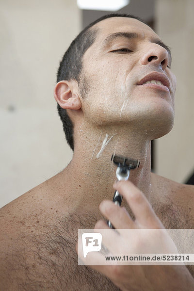 Man shaving in bathroom