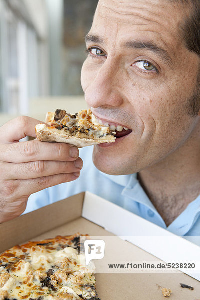 Nahaufnahme eines Mannes  der Pizza isst