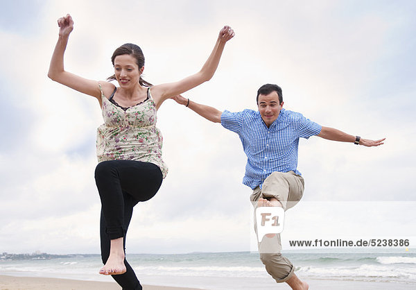 Couple jumping on beach
