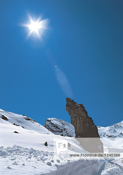 Spur in verschneiter Berglandschaft  Sonne
