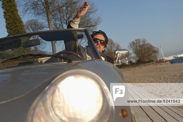 Mann fährt klassisches Cabriolet