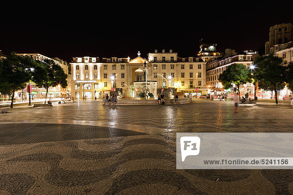 Europe  Portugal  Lisbon  Baixa  View of Bronze fountain near Teatro Nacional Dona Maria II at Rossio with wave patterns on cobblestone pavement in foreground