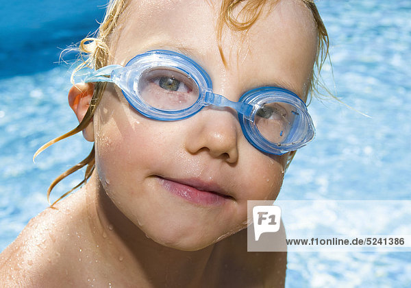 Kleiner Junge an Pool mit Schwimmbrille  Porträt