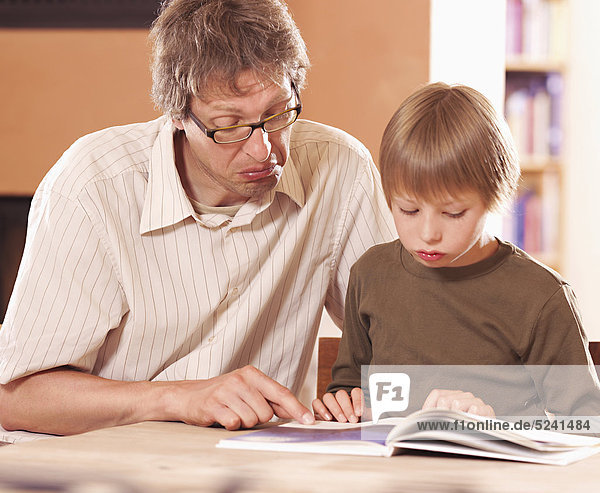 Vater mit Sohn beim Lesen