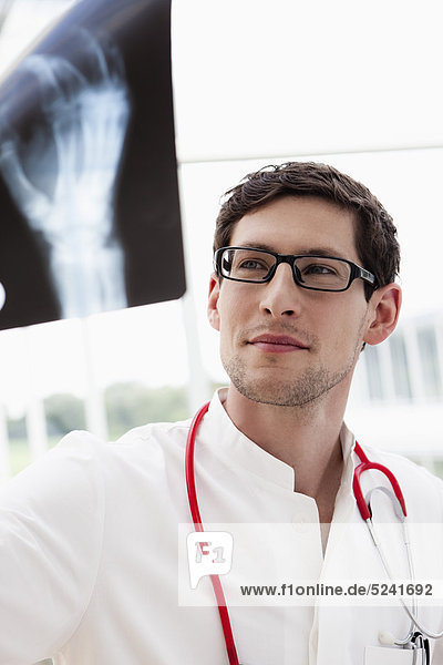 Deutschland  Bayern  Diessen am Ammersee  Junger Arzt beim Röntgen  Lächeln  Nahaufnahme