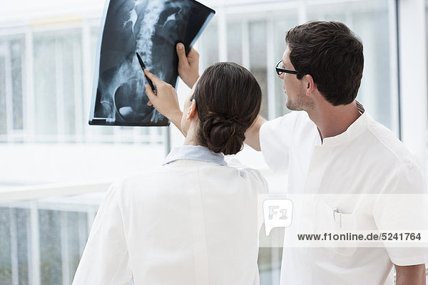 Germany  Bavaria  Diessen am Ammersee  Two young doctors examining x-ray