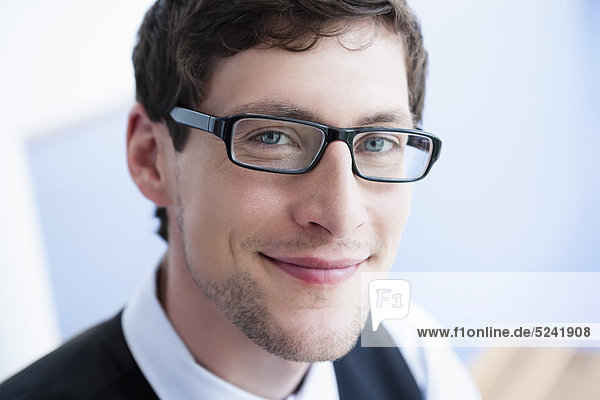 Germany  Bavaria  Diessen am Ammersee  Close up of businessman in thick spectacles  smiling  portrait