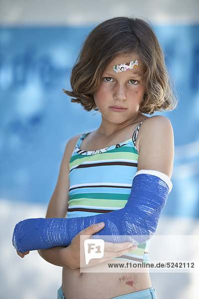 Wounded girl in swimwear and with broken arm  portrait