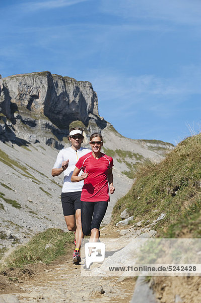 Austria  Kleinwalsertal  Man and woman running on mountain trail