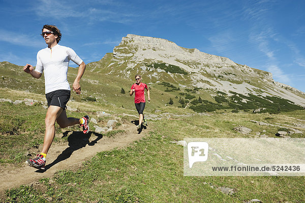 Austria  Kleinwalsertal  Man and woman running on mountain trail