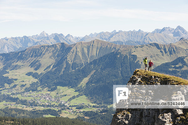 Austria  Kleinwalsertal  Man and woman hiking on edge of cliff