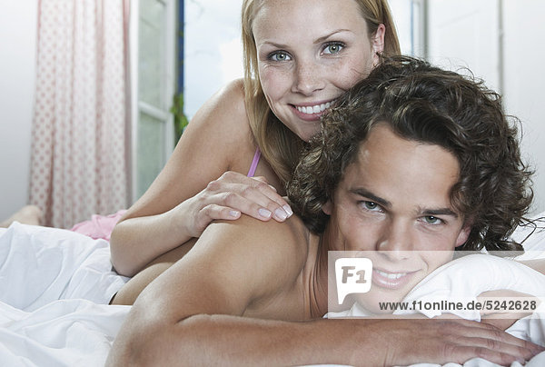 Italien  Toskana  Junges Paar im Hotelzimmer auf dem Bett liegend