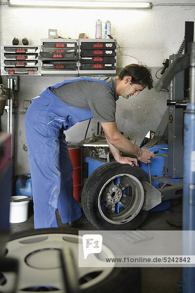 Deutschland  Ebenhausen  Mechatroniker für Reifen in der Autowerkstatt