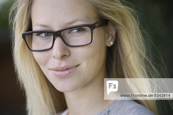 Junge Frau mit dicker Brille  lächelnd  Nahaufnahme