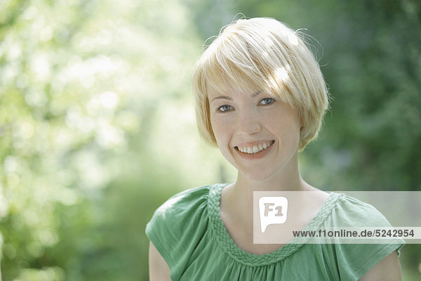 Nahaufnahme einer jungen Frau im Park  Portrait  Lächeln