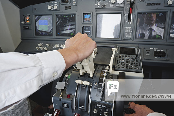 Germany  Bavaria  Munich  Hands of pilot and co-pilot piloting aeroplane from airplane cockpit