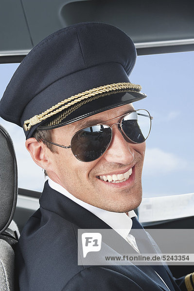 Deutschland Bayern München Pilot mit Fliegerbrille im Flugzeugcockpit Nahaufnahme