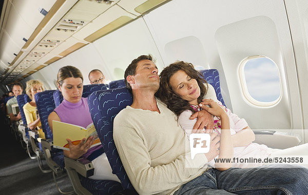 Germany  Munich  Bavaria  Passengers sleeping in economy class airliner