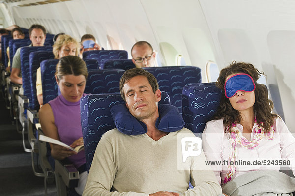 Germany  Munich  Bavaria  Passengers sleeping in economy class airliner