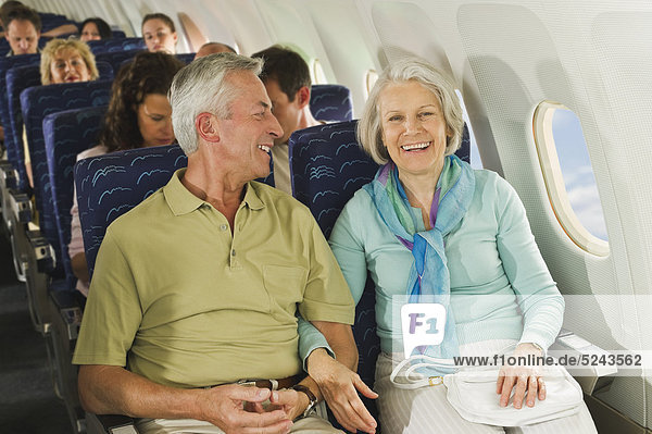 Germany  Munich  Bavaria  Group of passengers in economy class airliner  smiling