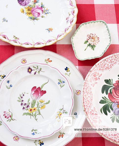 Floral patterned porcelain plates on checked table cloth