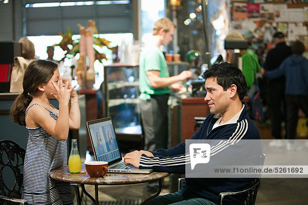 Vater und Tochter mit Laptop im Café