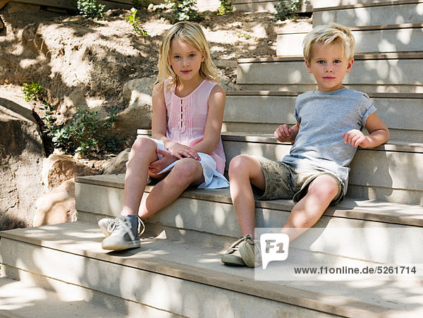 Brother and sister sitting on wooden steps  portrait