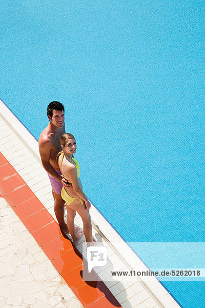 Young couple standing at poolside