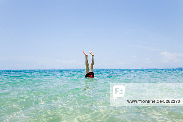 Schwimmer mit aus dem Wasser ragenden Beinen vor Penhentian Kecil  Perhentian Islands  Malaysia