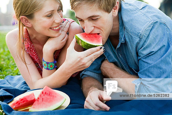 Junge Frau füttert Mann Wassermelone