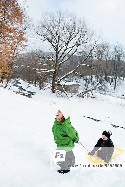 Two children sledging in snow