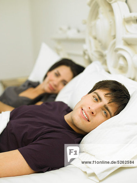 Young couple lying in bed