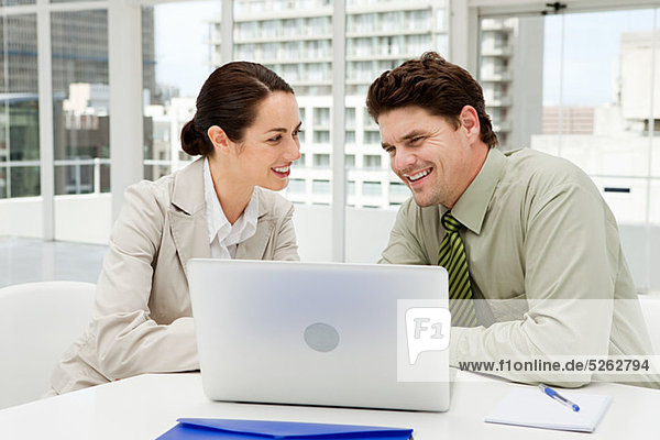 Geschäftsmann und Geschäftsfrau treffen sich im Büro mit Laptop