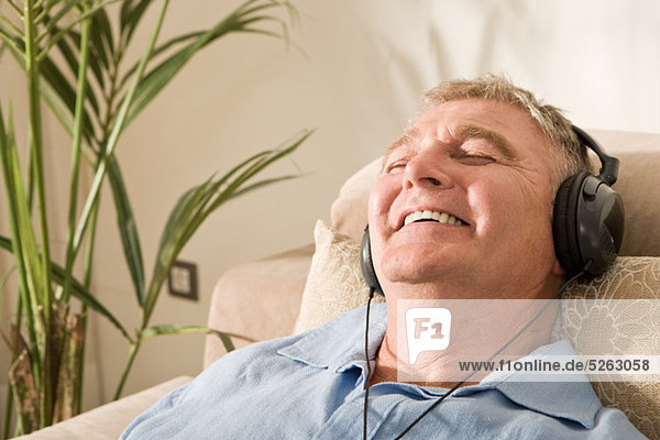 Senior Man relaxing mit Kopfhörer auf