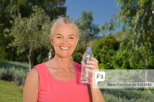 Reife Frau Runner mit Flasche Wasser