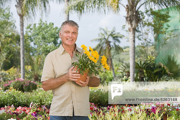 Senior Man mit Topfpflanze an Gartencenter