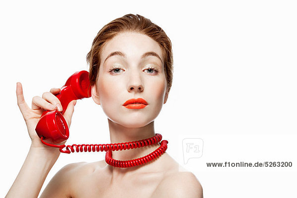 Frau mit roter Telefonschnur um den Hals gewickelt