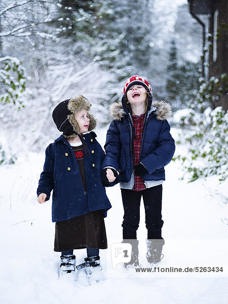 Two girls standing in winter back yard