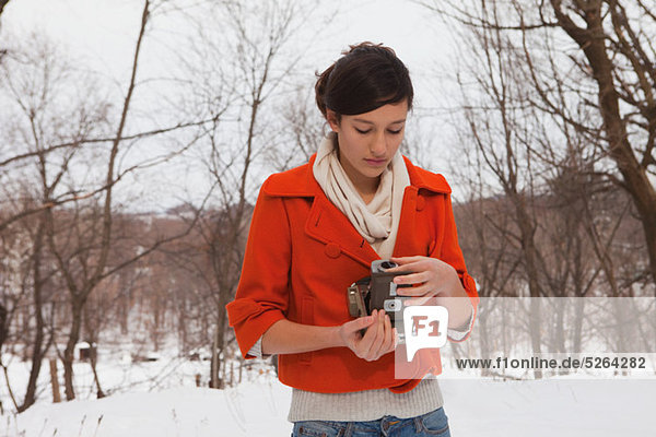 Teenage Girl holding von Jahrgang Kamera im Schnee