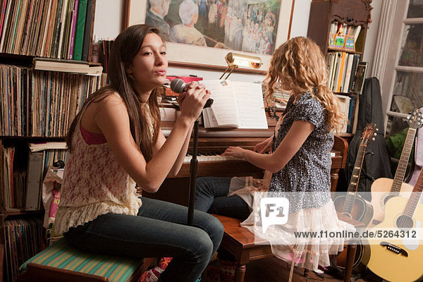 Teenagermädchen spielen Klavier und singen