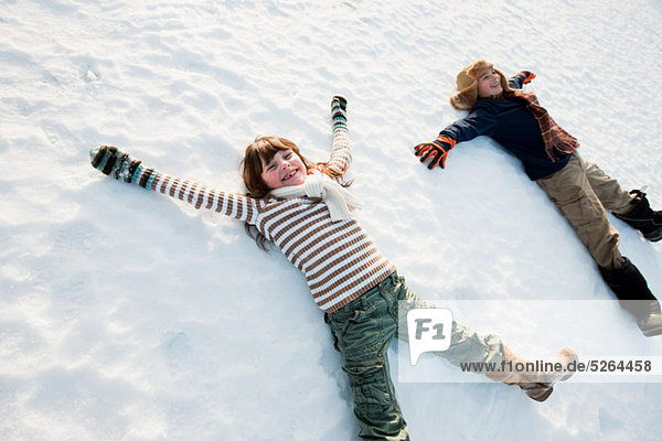 Kinder machen Schnee-Engel