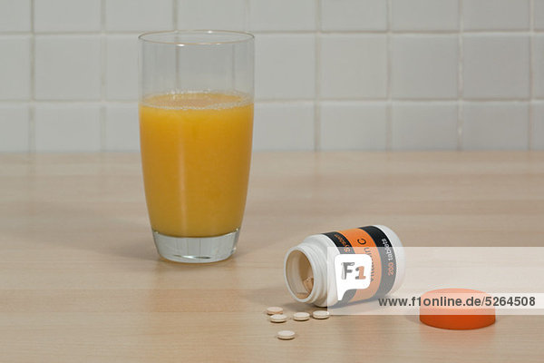 Vitamin-C-Tabletten und Glas Orangensaft