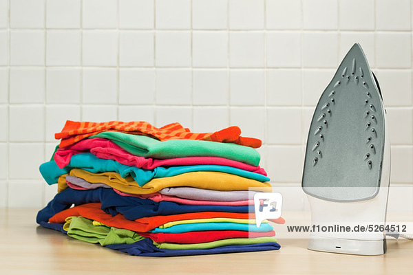Haufenweise saubere Wäsche und Bügeleisen
