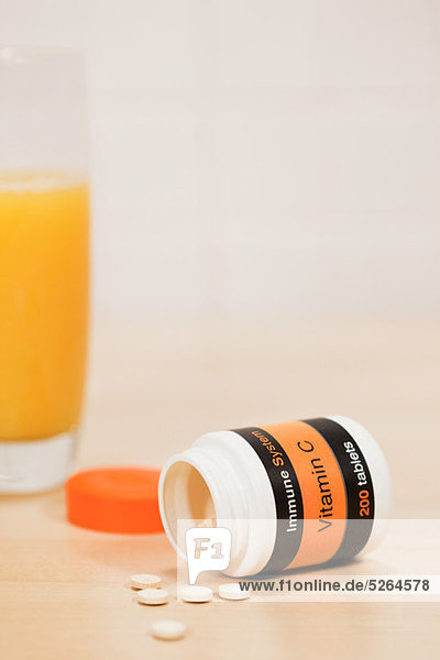 Glas Orangensaft und Vitamin C-Tabletten