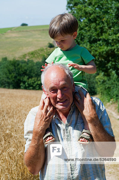 Grandfather carrying grandson on shoulders  portrait