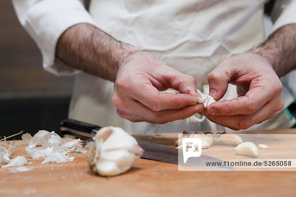 Chef adding peeling garlic