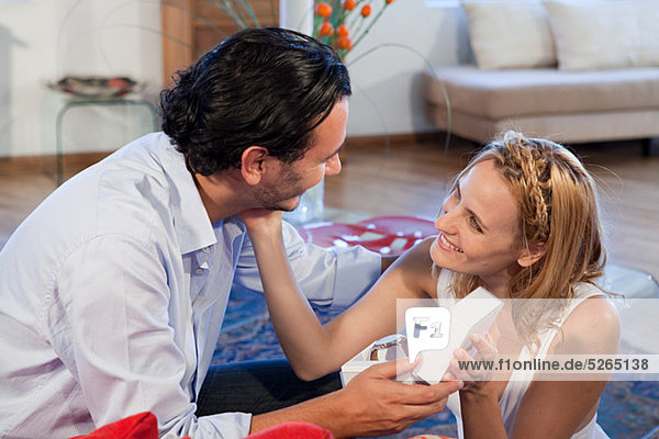 Woman giving gift of wrist watch to boyfriend