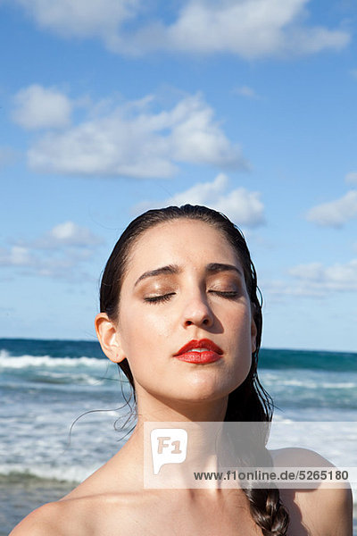 Woman on beach with eyes closed